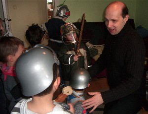 Spielleiter Robert Mingau und einige kleine Ritter sind in einem Kinderzimmer mit Vorbereitungen für ein Ritterturnier beschäftigt