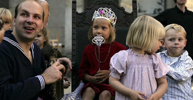 Robert Mingau - Spielleiter, Kinderanimateur und Klabautermann von Berlin - kniet vor dem Thron einer kleinen Prinzessin mit silberner Krone und Zepter