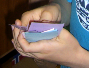 ein Bündel Spielgeldscheine in einer Kinderhand