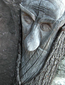 koboldartiges Wesen, aus einem Baumstamm geschnitzt