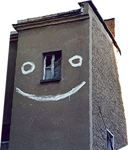 ein altes Haus mit lachendem Gesicht zwischen den Fensterscheiben