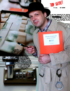 Robert Mingau als Kommissar Fuchs: Bildmontage mit Zahlenschloss und Geldkoffer