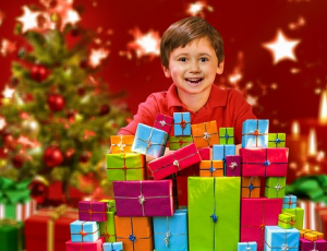 ein Junge schaut hinter einem Berg von Geschenkpäckchen hervor und freut sich